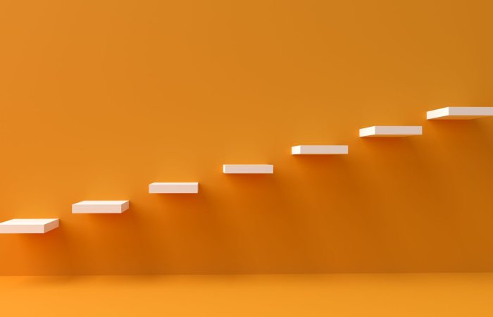 White floating steps on vibrant orange wall create a minimalist and conceptual design.