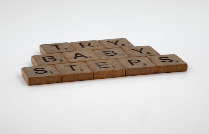 Scrabble tiles forming the phrase 'Try Baby Steps' on a white background.